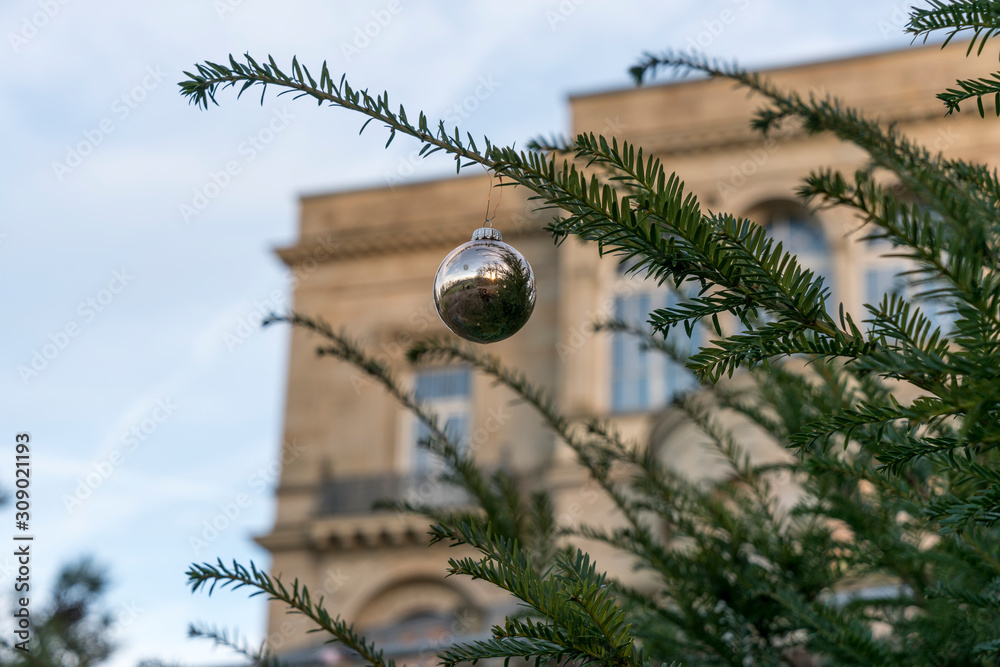 Weihnachtskugel an grünem Zweig, Villa Berg, Stuttgart unscharf im Hintergrund