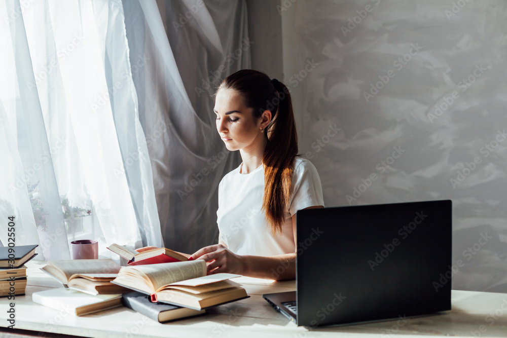 girl works at the computer reads books girl works at the computer reads books