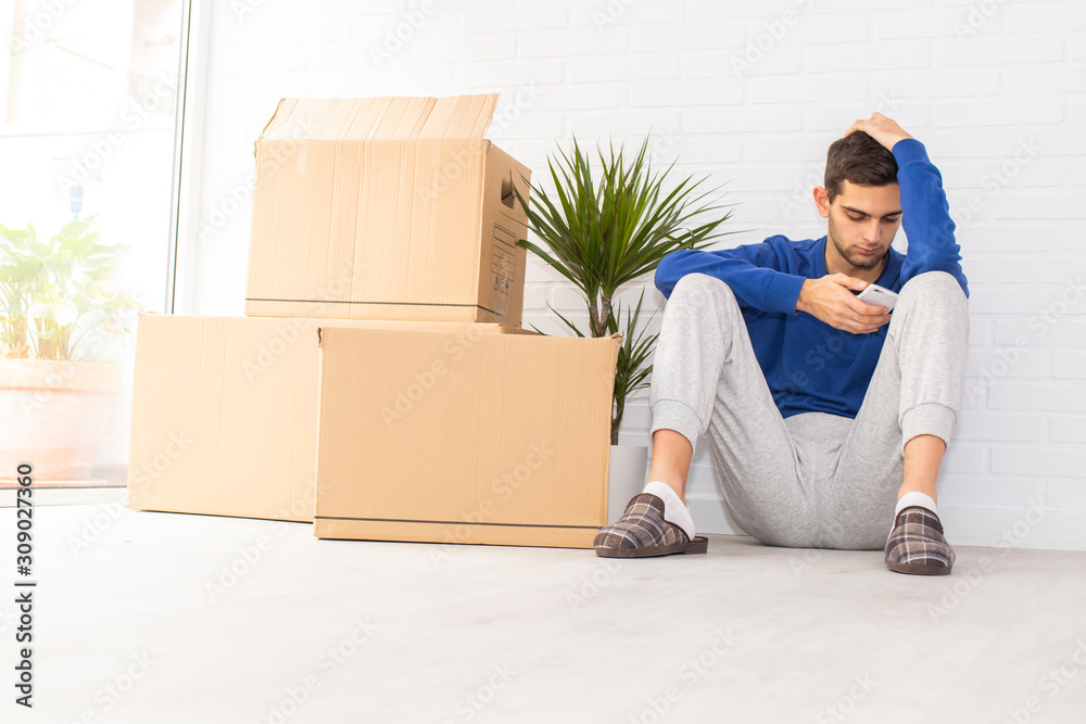 young man in the apartment with moving and mobile phone young man in the apartment with moving and mobile phone