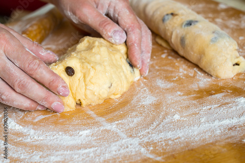 Female hands prepare yeast dough with raisins for pies