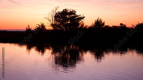 Sunset over Assateague Island over marshes, salt water bay with silhouette