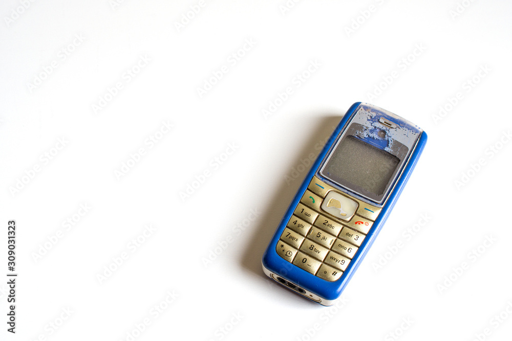 Old mobile phone on a white desk. top view, copy space. Old mobile phone on a white desk. top view, copy space.