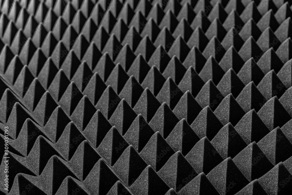 Abstract background in the form of pyramids and dragon scales. Acoustic black foam rubber.
