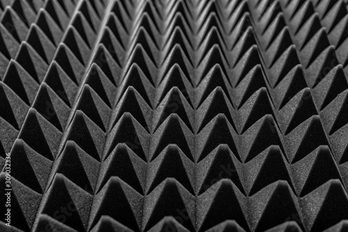 Abstract background in the form of pyramids and dragon scales. Acoustic black foam rubber.