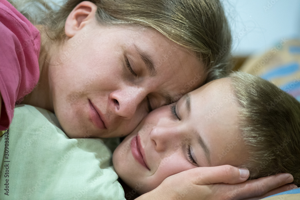 Happy mother and son sleep together hugging each other. Happy mother and son sleep together hugging each other.