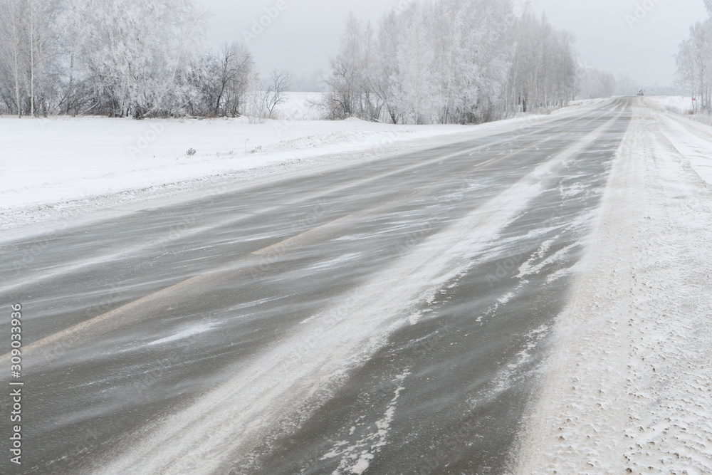 Obraz premium The wind blows off the snow along the highway.