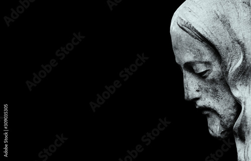 Profil of Jesus Christ isolated on black background. (ancient statue)