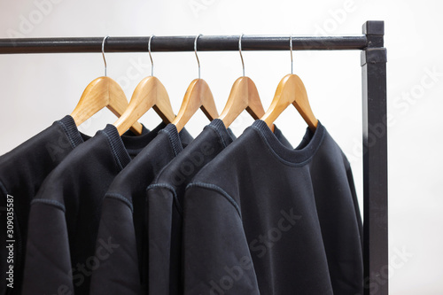 Blank sweatshirts hanging on a hanger in the wardrobe or showroom photo
