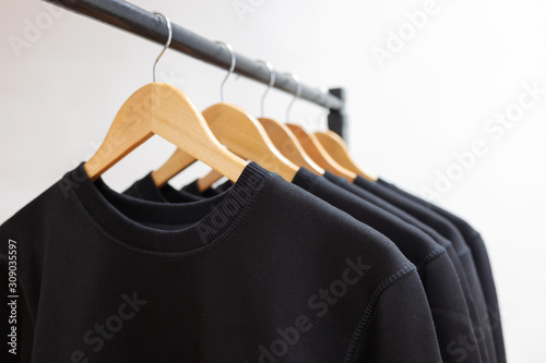 Blank sweatshirts hanging on a hanger in the wardrobe or showroom photo
