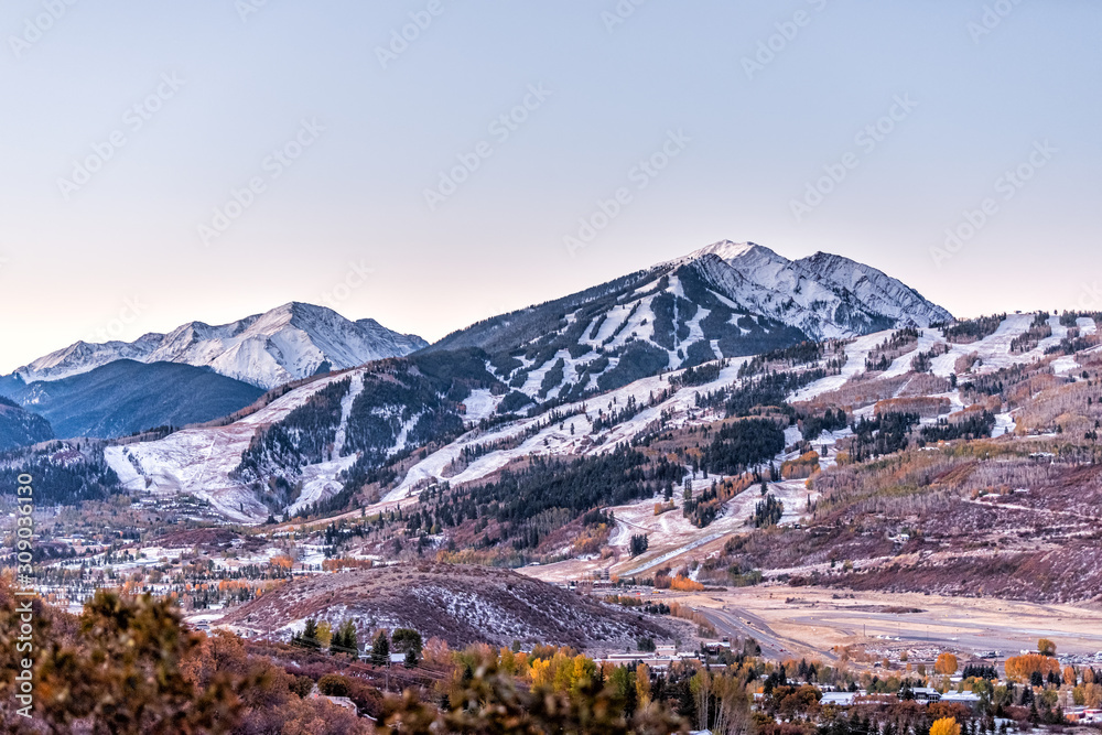 Aspen, Colorado rocky mountains high angle view of snow covered highlands and small airport runway in roaring fork valley in autumn