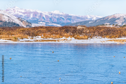 Independence Pass highway 82 rocky mountain continental divide in autumn Colorado with winter snow and closeup surface of lake photo
