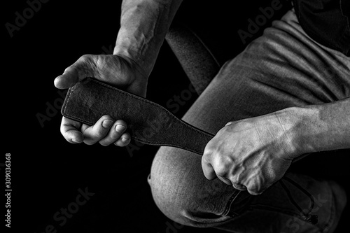 Strict man with paddle. BDSM concept.