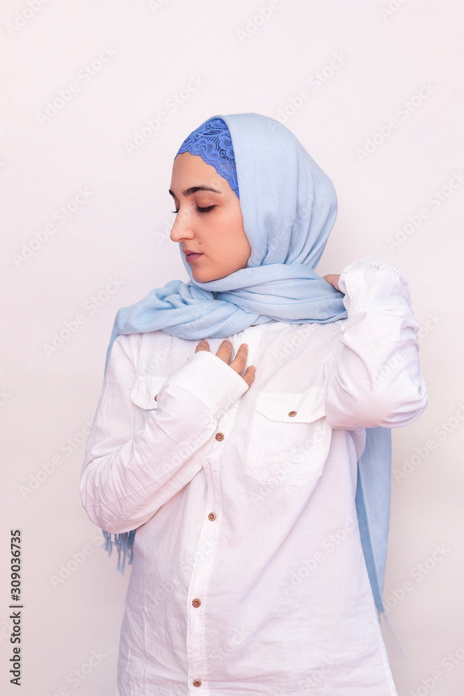 Elegant Muslim woman in white shirt and bright blue hijab. Stylish Iranian  girl in Muslim clothing. Isolated portrait of attractive middle-eastern  woman Stock-Foto | Adobe Stock