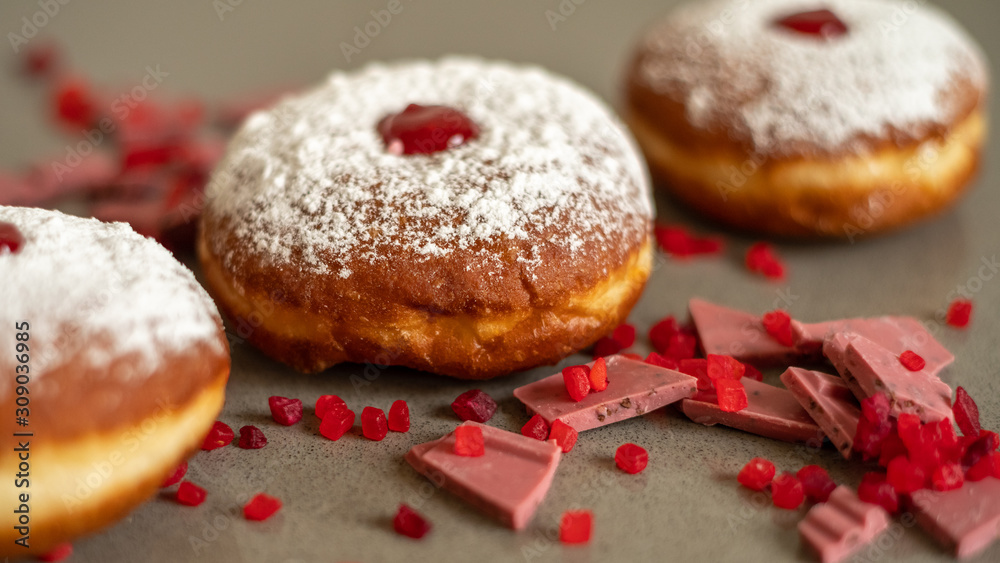 Hanukkah background with fresh donuts and pink ruby chocolate.