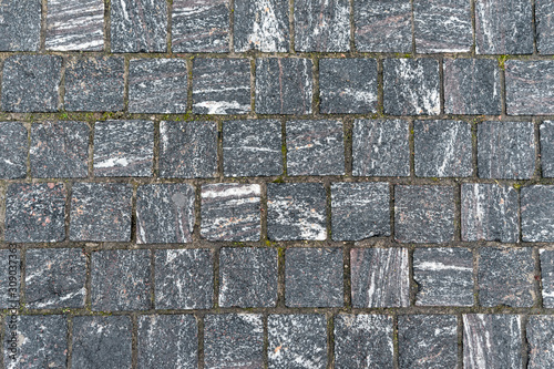 Texture of gray square road granite tiles. Stone background. Modern paving slabs. Motley pattern.