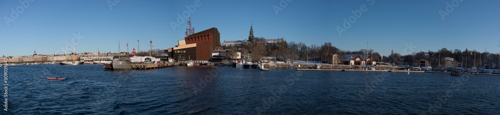 Panorama view over a snowy Stockholm inner harbour a sunny winterday with boats and landmarks