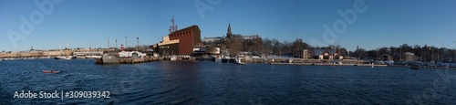 Panorama view over a snowy Stockholm inner harbour a sunny winterday with boats and landmarks