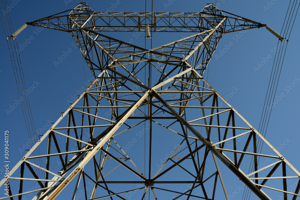 Steel lattice suspension electric tower with high tension power lines and blue sky
