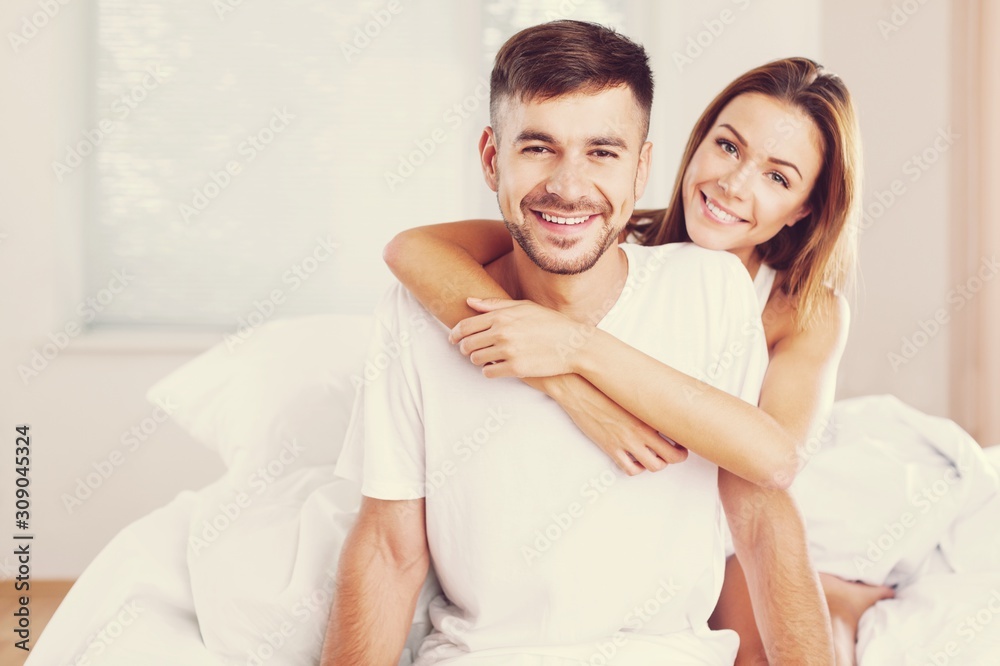 Young woman wakeup after sleeping on the white linen in bed at home Young woman wakeup after sleeping on the white linen in bed at home