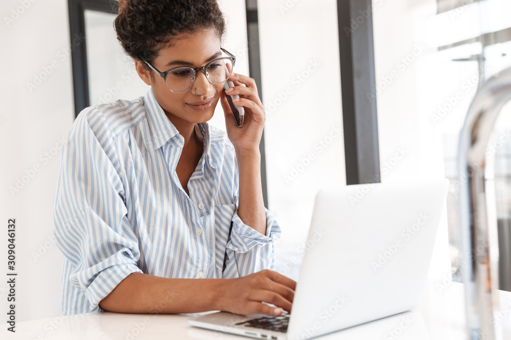 Attractive young african woman working on laptop computer Attractive young african woman working on laptop computer