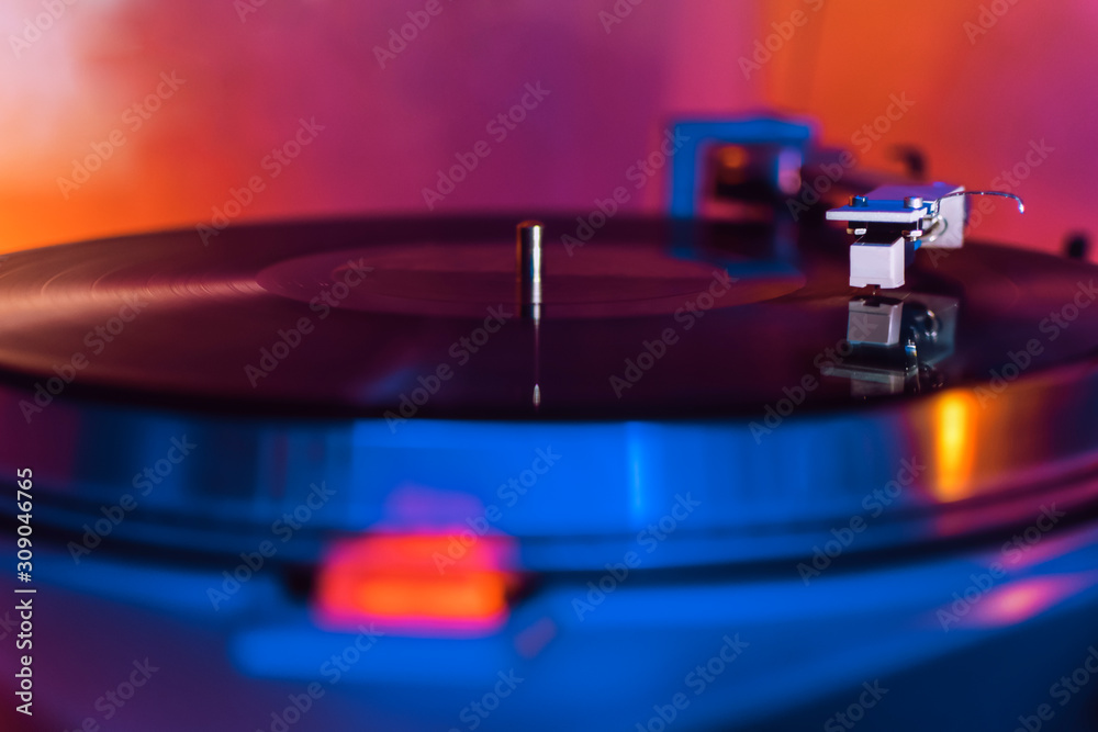 Fototapeta premium vinyl needle on a record in blue and orange tones. selective focus