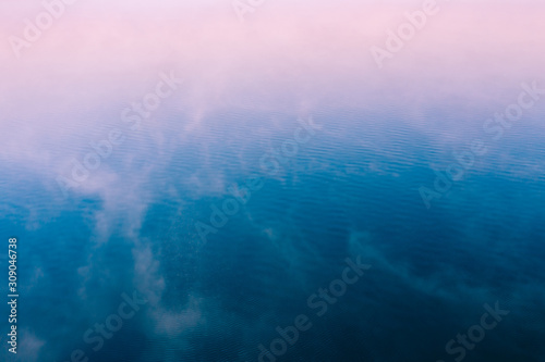 Pink fog over blue water surface  aerial view. Tranquil natural background