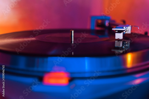 vinyl needle on a record in blue and orange tones. selective focus