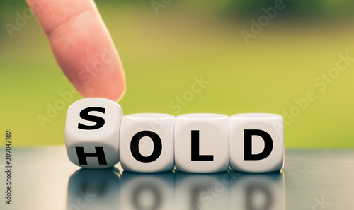 Hand turns a dice and changes the word "hold" to "sold".