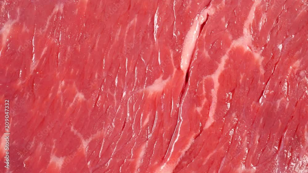 Angus beef rotating. Flat meat surface. Uncooked fresh beef. Top view. 4K 422 10 bit Angus beef rotating. Flat meat surface. Uncooked fresh beef. Top view. 4K 422 10 bit