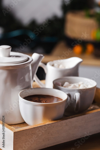 A cup of hot chocolate with a sugar bowl and teapot on the New Years table. Christmas decoration