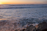 Bonito pôr do sol no mar com ondas e pedras