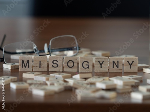 misogyny the word or concept represented by wooden letter tiles photo
