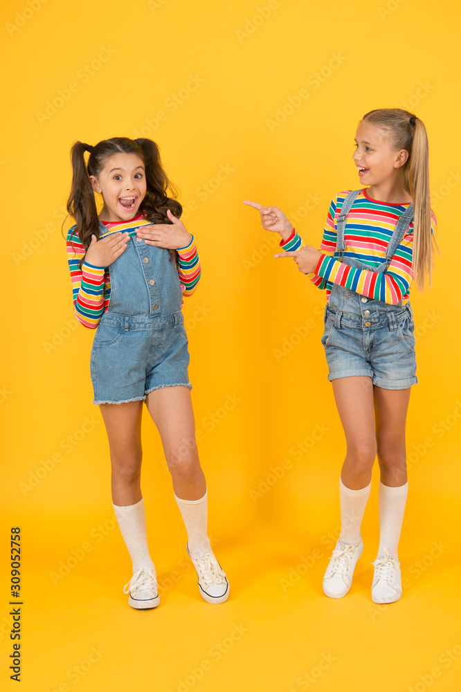 Best friends. Trendy and fancy. Emotional kids. Fashion shop. Modern fashion.  Kids fashion. Little girls wearing rainbow clothes. Happiness. Girls long  hair. Cute children same outfits communicating Stock Photo