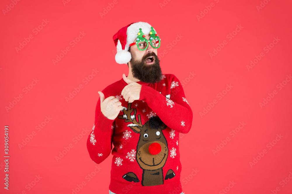 Fototapeta premium Pre-Christmas Delivery. bearded man santa hat red wall. merry christmas. male in xmas party glasses. happy new year. funny hipster knitted sweater. warm cloth for cold weather. winter holiday season