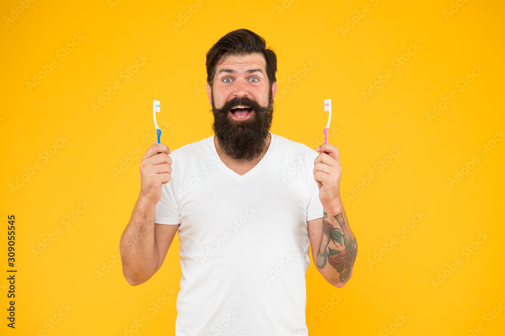 Mouth matters. Bearded man happy smile with toothbrushes. Happy hipster hold brushes yellow background. Dental hygiene. Dental clinic. Gentle dental care. Dental health Mouth matters. Bearded man happy smile with toothbrushes. Happy hipster hold brushes yellow background. Dental hygiene. Dental clinic. Gentle dental care. Dental health