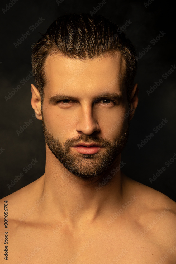 Handsome sport sexy stripped guy portrait for cosmetics and fitness on isolated black background