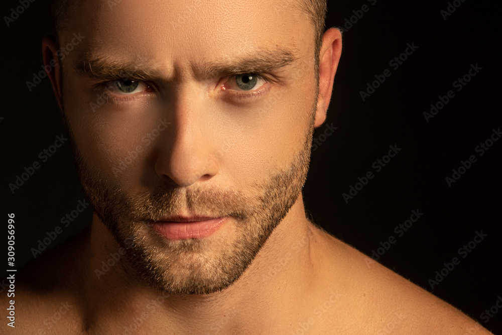 Naklejka premium Handsome sport sexy stripped guy portrait for cosmetics and fitness on isolated black background