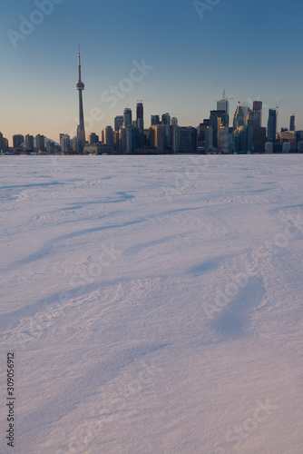 Toronto city skyline in winter from snow covered Lake Ontario at sunset