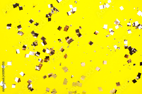 Fototapeta Naklejka Na Ścianę i Meble -  Falling silver confetti on yellow backdrop. Holiday concept.