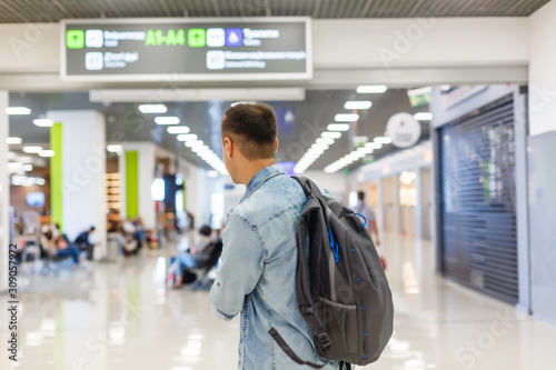 portrait of a happy male traveler walking with backpack