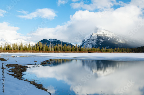 Majestic snowy mountain landscape with a frozen lake in foreground. Vermilion lakes, Banff National Park, Canada