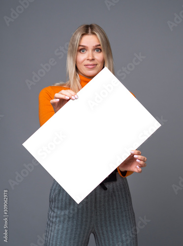 Joyful girl holding a diagonally tilted big paper sheet A1 with copy space for mockup