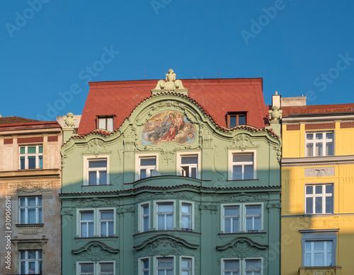 Beautiful green, yellow and pink ancient historical residential house facades with fresco at Letna, Prague, Czech Republic. Blue sky background