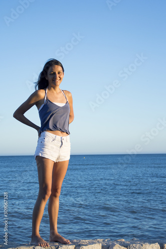 Young girl standing with sky and beach background