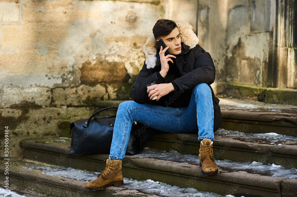 Portrait of a young handsome boy in the winter in the street