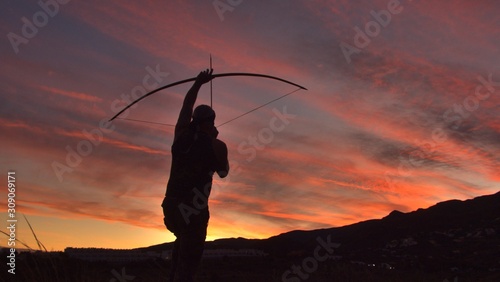 Die Silhouette eines Bogenschützen bei Sonnenuntergang