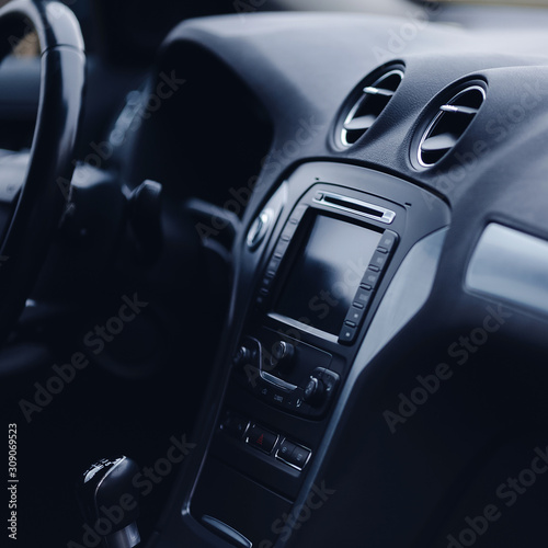 Modern car interior. Steering wheel, gearshift lever, multimedia system, driver's seat and dashboard.