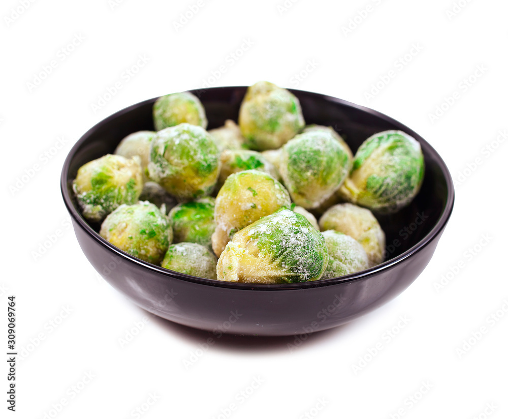 Frozen Brussels cabbage in black clay bowl isolated on a white background.