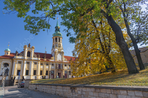 PRAGUE, CZECH REPUBLIC - OCTOBER 14, 2018: The Loreto baroque church and autumn tree. © Renáta Sedmáková