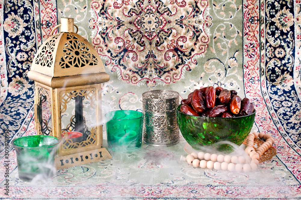 Fototapeta premium Ramadan lamp, candles, dates in green bowl and rosary with smoke.